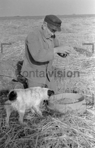 Bauer auf dem Feld mit Sack und Hund